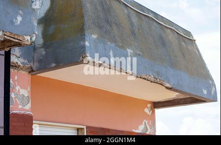 Wall with cracked concrete and rusty irons requiring renovation. Stock Photo