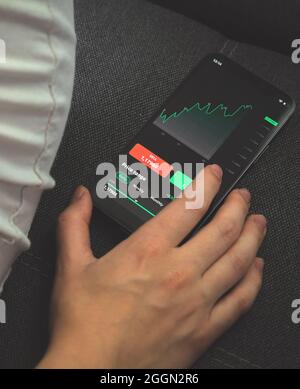 Investor analyzing stock market graph on mobile phone. Screen with financial graphs, concept photo of trading and exchange Stock Photo
