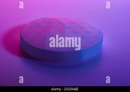 Round stone with carving under blue purple and red neon lights Stock Photo