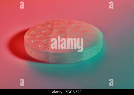Round stone with carving under blue purple and red neon lights Stock Photo