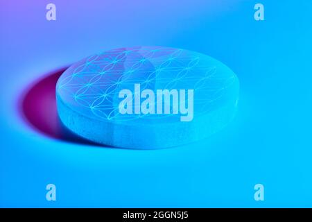 Round stone with carving under blue purple and red neon lights Stock Photo