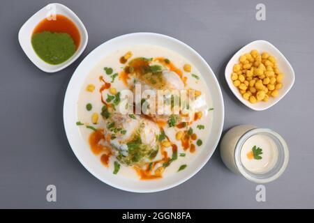 Dahi Bhalla or Dahi Vada is a type of chaat dish from India. It is prepared by soaking urad dal vadas in creamy yogurt with green and red chutney. Stock Photo