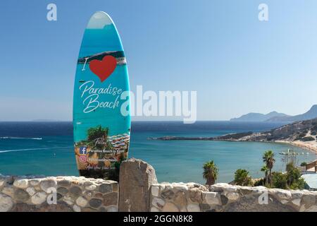 Surfboard advertising Paradise beach - a popular sandy beach in Kefalos, Kos, Dodecanese Islands, Greece Stock Photo