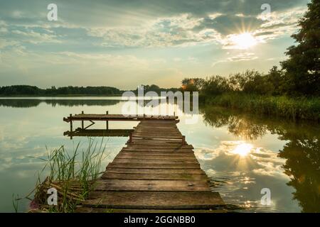 Sunlight reflecting on the lake with a pier Stock Photo