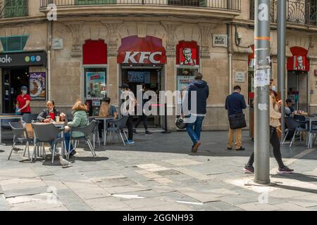 Palma de Mallorca, Spain; april 23 2021: Main facade of the franchise restaurant Kentucky Fried Chiken KFC in Plaza de España. Citizens wearing face m Stock Photo
