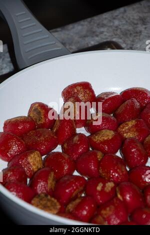 homemade red gnocchi colored with healthy beetroot juice fried in a pan Stock Photo