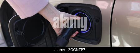 Woman hand holding charger for car closeup Stock Photo