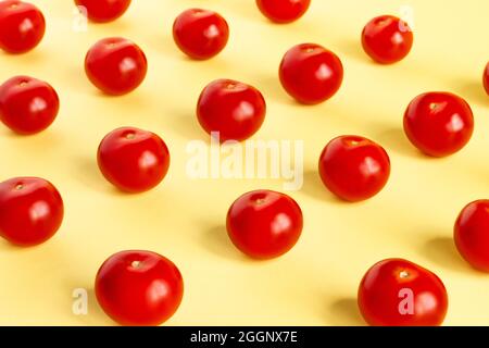 Pattern of red tomatoes on a light yellow background Stock Photo