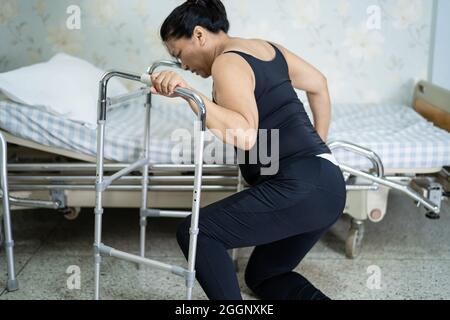 Asian middle-aged lady woman patient falling in living room because slippery surfaces Stock Photo