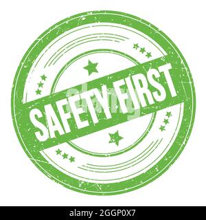 SAFETY FIRST text on green round grungy texture stamp. Stock Photo