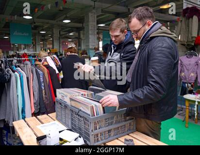 Flea market. Two men standing at the counter buying old records. September 26, 2019. Kyiv, Ukraine Stock Photo