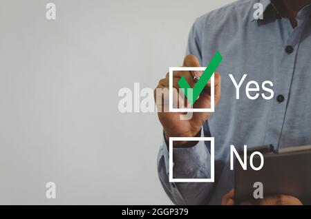 businessman holding a pen with a green check mark on the square on a virtual screen Stock Photo