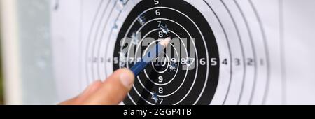 Man showing with pencil to shots on paper target closeup Stock Photo