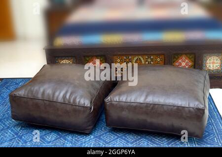 leather floor cushion with green background selective focus color brown Stock Photo
