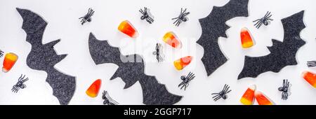 Halloween frame background. Bat and spider decorations with traditional trick o treat candy corn on white background. Halloween greeting card. Flat la Stock Photo