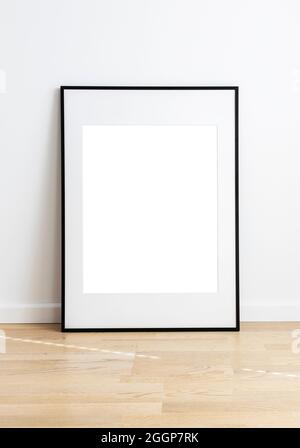 Rectangular mock up standing in a room with wooden flooring and white wall. Stock Photo