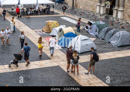 Barcelona, Spain. 02nd Sep, 2021. People walk by the tent camp installed during a strike in Plaza de Sant Jaume.Second day of hunger strike in Plaza Sant Jaume by businessmen and nightlife workers after the TSJC (Supreme Court of Justice of Catalonia) validated the arguments of the Generalitat de Catalunya to keep nightlife closed due to the so-called fifth wave of Covid19. Credit: SOPA Images Limited/Alamy Live News Stock Photo