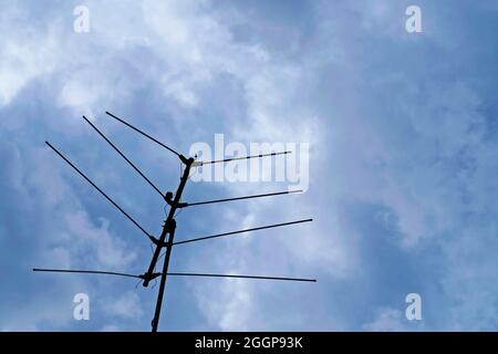 Old analog television antenna on cloudy sky background, Sao Joao del Rei, Brazil Stock Photo