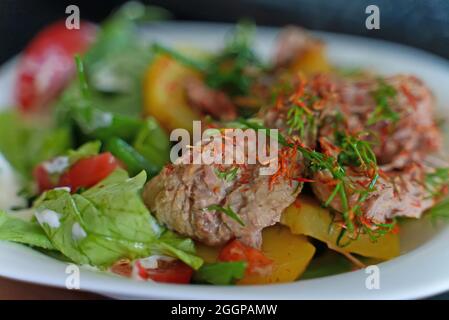 Pulled pork with potatoes and herbs. Stock Photo