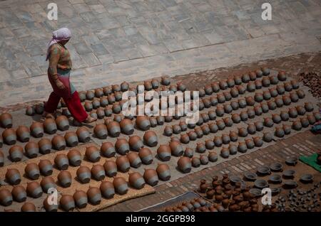 (210902) -- BHAKTAPUR, Sept. 2, 2021 (Xinhua) -- A woman looks after the clay pots kept for drying at a pottery square in Bhaktapur, Nepal, on Sept. 1, 2021.  Bhaktapur is known for its centuries-old pottery craft, which has been passed down through generations. The pottery produced in Bhaktapur is regarded superior to those made elsewhere, owing to the usage of black clay which can be found only in one place and can only be dug once a year by Bhaktapur natives. (Xinhua/Sulav Shrestha) Stock Photo