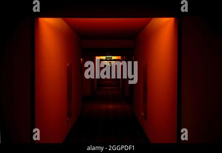 Empty hotel corridor with poor illuminated hall in red color Stock Photo
