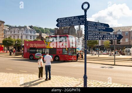 Rothesay tourism - tourist road sign and double decker hop on hop off tourist bus - Rothesay, Isle of Bute, Scotland, UK Stock Photo