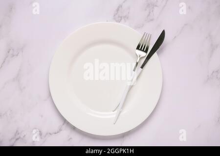 Clean empty white plate with cutlery. Copy space, mock up, top view. Concept for menu with utensil. Stock Photo