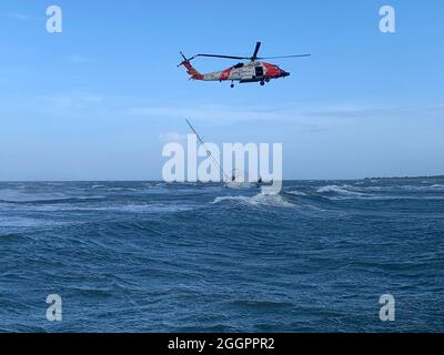 Chincoteague, United States Of America. 01st Sep, 2021. Chincoteague, United States of America. 01 September, 2021. A U.S. Coast Guard rescue swimmer rappels down to rescue three mariners stranded in Chincoteague Harbor during severe weather as the remnants of Hurricane Ida passed through September 1, 2021 in Chincoteague, Virginia. Credit: CPO Ross Comstock/Coast Guard/Alamy Live News Stock Photo