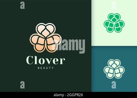 Clover leaf logo in luxury gold color represent lucky or herb Stock Vector