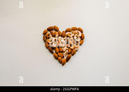 Nuts are laid out on a white background in the shape of a heart. Stock Photo