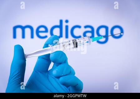 Esp. 02nd Sep, 2021. In this photo illustration a hand in medical gloves hold a syringe in front of Medicago logo in Barcelona, Spain on September 2, 2021. Medicago is a new vegetal vaccine against Covid-19 currently under development. (Photo by Davide Bonaldo/Sipa USA) Credit: Sipa USA/Alamy Live News Stock Photo