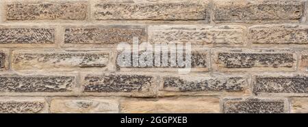 Rough sandy texture of an old stone brick wall Stock Photo