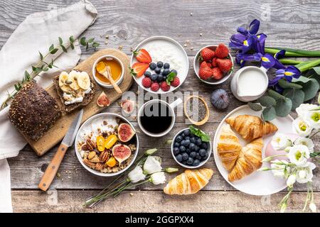Beautifully served table for breakfast with many delicacies, cheeses, salami, pastries, orange juice, tea and coffee. Stock Photo