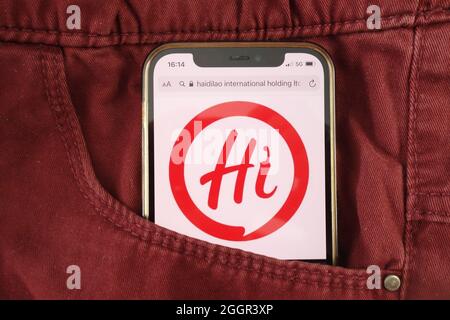 KONSKIE, POLAND - August 17, 2021: Haidilao International Holding Ltd logo displayed on mobile phone hidden in jeans pocket Stock Photo