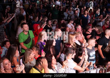 Odessa, Ukraine July 11, 2019: Many spectators at concert. crowd of visitors to concert has fun and shoots what is happening on smartphones. Fans at c Stock Photo