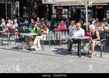 People sitting on a sunny terrace in summer at the main market square Stock Photo