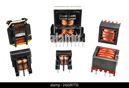 Set of isolation transformers, copper wire on inductors isolated on white background. Electromagnetic coils in device for transfer energy in circuits. Stock Photo