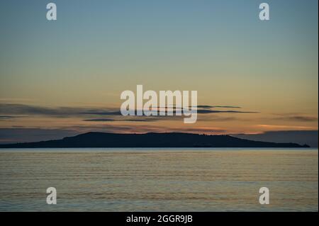 Beautiful early morning view of Howth seen from Blackrock Beach, Dublin, Ireland. Soft and selective focus. Sunrise marine themed. Island silhouettes Stock Photo