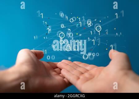 Floating virtual intelligence connections above hands on a blue background Stock Photo