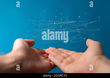 Floating virtual intelligence connections above hands on a blue background Stock Photo