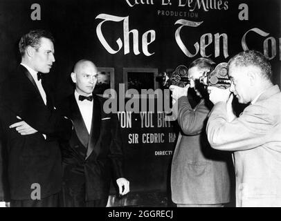 CHARLTON HESTON and YUL BRYNNER poses for Newsreel Cameramen outside the Criterion Theatre Times Square New York on November 8th 1956 at the World Premiere of THE TEN COMMANDMENTS 1956 director CECIL B. DeMILLE Motion Picture Associates / Paramount Pictures Stock Photo