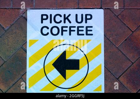 Covid-19 health and protection sign on pavement Pick up coffee sign with arrow for level 3 lockdown and lower.. Stock Photo