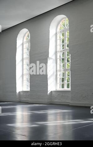 Two long arched windows in a white painted brick wall indoors in a large historic building, architecture and interior concept, copy space, selected fo Stock Photo