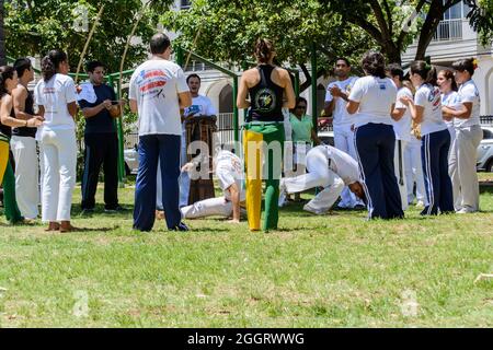 Salvador, Bahia, Brazil - February 23, 2014: Group of capoeristas making art in a square with green grass on a bright sunny day. Stock Photo