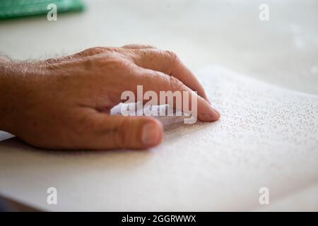 Detail of fingers reading a book in braille. Reading for the disabled with blindness Stock Photo
