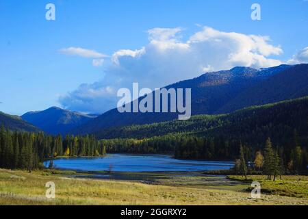 The Bay of the Gods at Kanas Lake. Tranquil water, trees, mysterious clouds. The natural beauty of the paradise. Kanas Nature Reserve. Xinjiang Provin Stock Photo