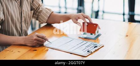 Real estate agent offer hand for customer sign agreement contract signature for buy or sell house. Real estate concept contact agreement concept Stock Photo
