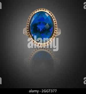 Beautiful blue wedding engagement  ring with halo gemstone band Jewelry on a dark background Stock Photo