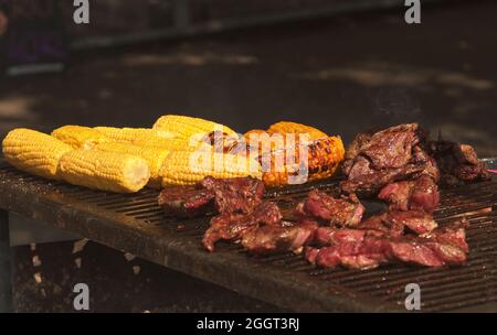 Grilling season, barbecue grill with marinated meat and nice yellow corn Stock Photo