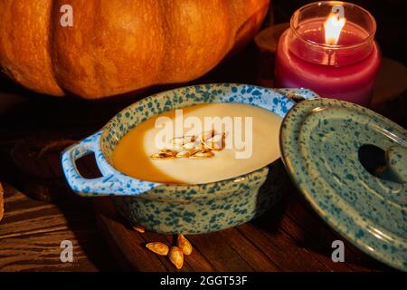 Halloween with candles with pumpkin and cream soup on spooky night - Halloween scene. Stock Photo